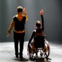 Link, On Beauty, Bühnenaufnahme, Rückansicht eines stehenden Mannes und einer Frau im Rollstuhl.