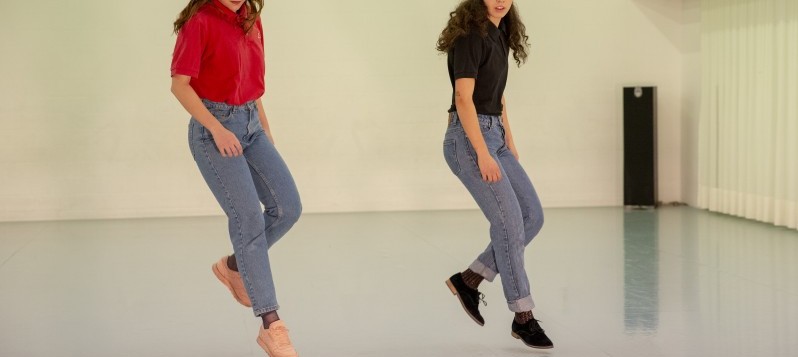 Zwei junge Frauen tanzen.