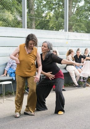 Vorstellungsaufnahme draussen von Face the music...and dance. Zwei Frauen tanzen draussen mit Armgesten.