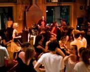 Viele Menschen tanzen zu Musik in einem Raum. Foto: Sabine Burger
