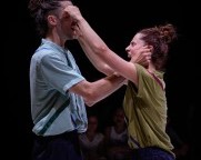 Bühnenaufnahme des Stückes «Equality». Ein Mann und eine Frau greifen einander mit aufgerissenen Mündern mit beiden Händen ins Gesicht 