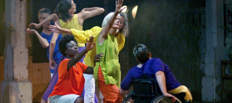 Sechs Tänzerinnen bilden von links nach rechts eine überlappende Reihe. Ihre ausgestreckten oder angewinkelte Arme ragen in unterschiedliche Richtungen.